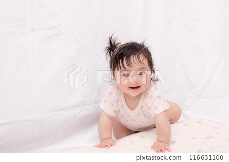 [A baby with tied hair starting to crawl] 116631100