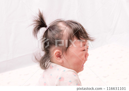 [Crying baby with tied hair starting to crawl] 116631101