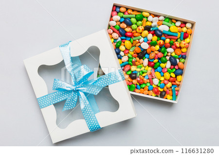 Box with sweet chocolate candies on color background, Various candy sweets. Valentines day gift box. Top view flat lay with copy space 116631280