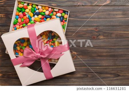 Box with sweet chocolate candies on color background, Various candy sweets. Valentines day gift box. Top view flat lay with copy space Box with sweet chocolate candies on color background, Various candy sweets. Valentines day gift box. Top view flat lay with copy space 116631281