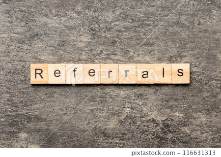 REFERRALS word written on wood block. REFERRALS text on cement table for your desing, concept REFERRALS word written on wood block. REFERRALS text on cement table for your desing, concept 116631313