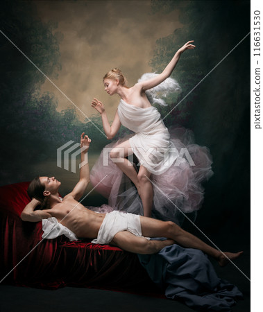 Elegant man and woman in period attire showing affection to each other against dark vintage background. Eternal love 116631530