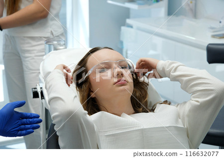 female dentist examining young girl patient's teeth at dental clinic. Doctor probing teeth with dental instrument using an explorer look for cavities treatment and checking problems with filling female dentist examining young girl patient's teeth at dental clinic. Doctor probing teeth with dental instrument using an explorer look for cavities treatment and checking problems with filling 116632077