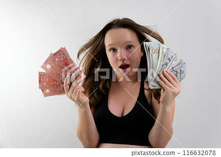 Girl Canadian dollars American dollars Exchange Learning Concept. Studio portrait of pretty young student woman holding passport with tickets and money. 116632078