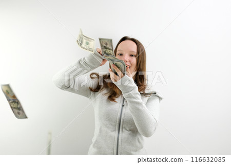 Throwing around dollars Teen throwing around dollar bills. Full length portrait of wasteful rich girl on orange background. Vertical frame Throwing around dollars Teen throwing around dollar bills. Full length portrait of wasteful rich girl on orange background. Vertical frame 116632085
