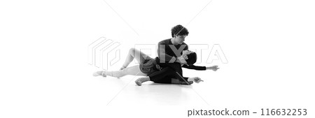 Banner. Ballet duo in fluid pose on floor with grace and precision against white studio background with negative space. Sepia filter. 116632253