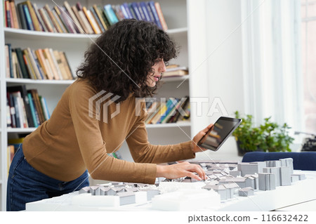 Woman architect using tablet at library table while creating city workout Woman architect using tablet at library table while creating city workout 116632422