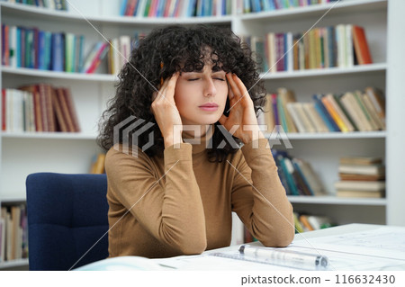 Woman architect working with blueprints in a well-stocked library Woman architect working with blueprints in a well-stocked library 116632430