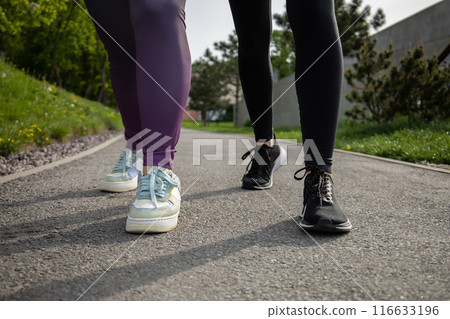 Unrecognizable women running during sunny morning Unrecognizable women running during sunny morning 116633196