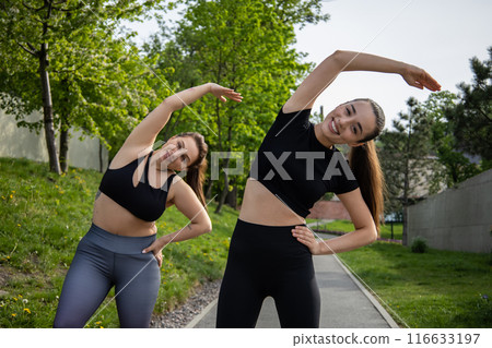 Woman with overweight warming up and exercising for dieting and health with her trainer in park Woman with overweight warming up and exercising for dieting and health with her trainer in park 116633197