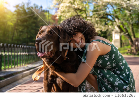 Happy dog owner with her pet spending good time in the park 116633263