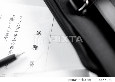 A freshly handwritten resignation letter and a black gel ink pen placed on a white desk with a business bag A freshly handwritten resignation letter and a black gel ink pen placed on a white desk with a business bag 116633970