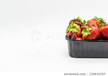 Strawberries in a dark plastic container against white background. Sweet and beautiful berry in a plastic container. Strawberries for sale. Strawberries in a dark plastic container against white background. Sweet and beautiful berry in a plastic container. Strawberries for sale. 116634297