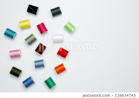 Multicolored sewing threads on white background. Top view, copy space Multicolored sewing threads on white background. Top view, copy space 116634743