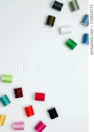 Multicolored sewing threads on white background. Top view, copy space Multicolored sewing threads on white background. Top view, copy space 116634775
