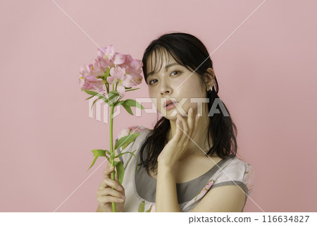 Portrait of a young woman with flowers on a pink background Portrait of a young woman with flowers on a pink background 116634827