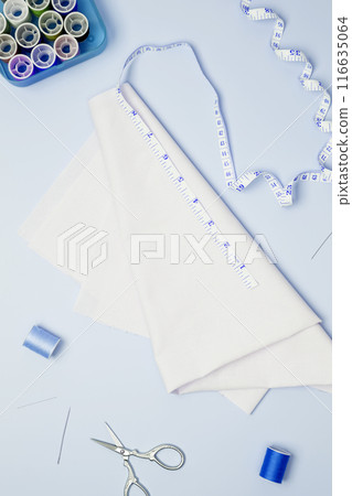 Composition with various threads and sewing accessories on blue background. Top view, copy space 116635064