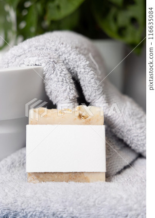 Soap bar with blank label on grey towels near vessel sink and green plant close up, mockup Soap bar with blank label on grey towels near vessel sink and green plant close up, mockup 116635084
