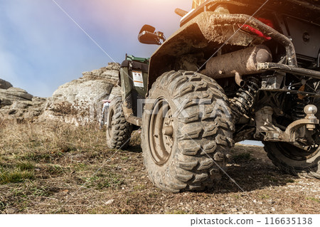 Close-up detail bottom POV view 4x4 awd ATV vehicle on dirt gravel unpaved road in autumn at misty mountain top. Offroad car mountain safari adventure nature trial journey concept. Quad bike rental Close-up detail bottom POV view 4x4 awd ATV vehicle on dirt gravel unpaved road in autumn at misty mountain top. Offroad car mountain safari adventure nature trial journey concept. Quad bike rental 116635138