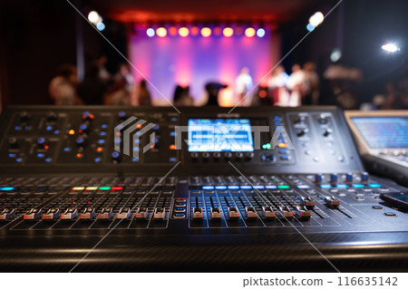 Live theater concert show sound video music control console with scene lights background. Sound engineer mixer soundboard equipment with many knobs, buttons, faders, equalizer screen and light Live theater concert show sound video music control console with scene lights background. Sound engineer mixer soundboard equipment with many knobs, buttons, faders, equalizer screen and light 116635142