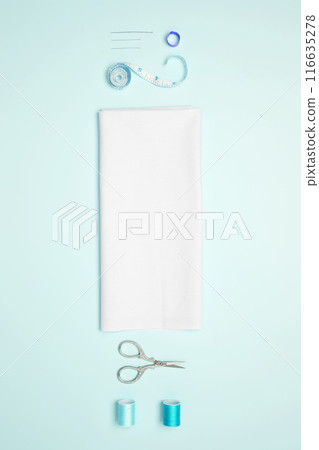 Composition with various threads and sewing accessories on blue background. Top view, copy space 116635278