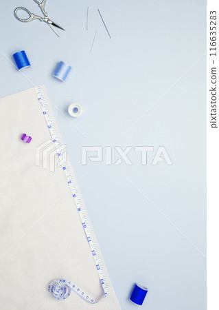 Composition with various threads and sewing accessories on blue background. Top view, copy space 116635283