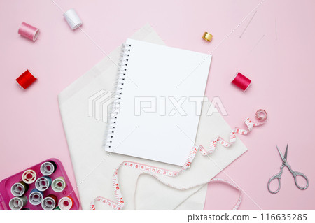 Composition with various threads and sewing accessories on pink background. Mock up notebook Composition with various threads and sewing accessories on pink background. Mock up notebook 116635285