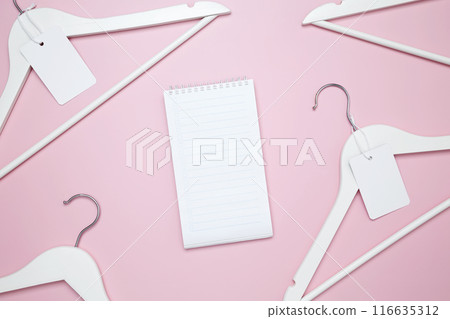 Creative flat lay hangers with white paper label. Clothing tag, label blank mockup template. Sale discount store promo shopping concept. Top view. Copy space 116635312