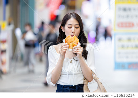 一位年輕女子在觀光時吃飯 一位年輕女子在觀光時吃飯 116636234