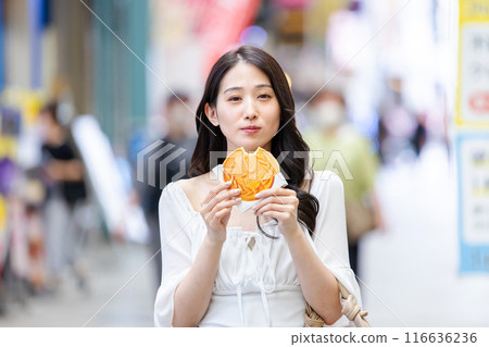 一位年輕女子在觀光時吃飯 一位年輕女子在觀光時吃飯 116636236