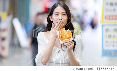 一位年輕女子在觀光時吃飯 一位年輕女子在觀光時吃飯 116636237