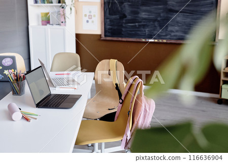 Background image of modern empty classroom equipped with laptops on large desk and blackboard on wall, copy space 116636904