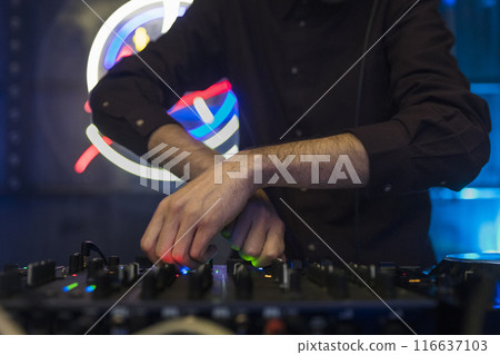 Close up view of a dj's hands playing the mixer while performing Close up view of a dj's hands playing the mixer while performing 116637103