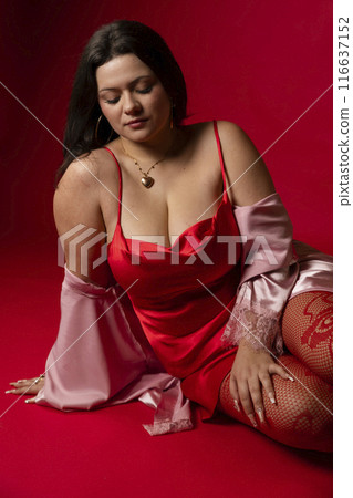 Curvy girl in red nightgown for studio portraits 116637152