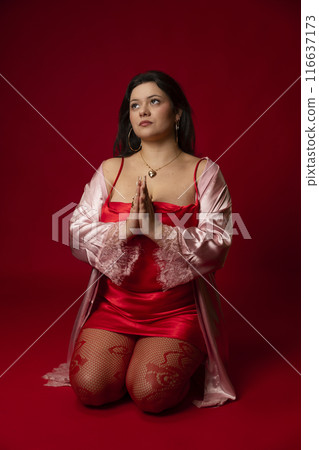 Curvy girl in red nightgown for studio portraits 116637173