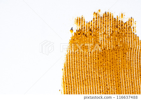 A smear of turmeric on a white background, top view 116637488