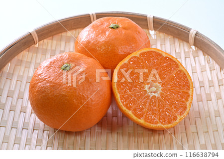 Cross section of 2 and a half greenhouse mandarins placed on a bamboo basket 116638794