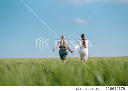 Two Beautiful woman in the green field. Nature, vacation, relax and lifestyle. Summer landscape. Two Beautiful woman in the green field. Nature, vacation, relax and lifestyle. Summer landscape. 116639176