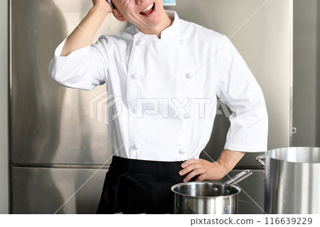 Worried young Asian female cook holding a pot Worried young Asian female cook holding a pot 116639229
