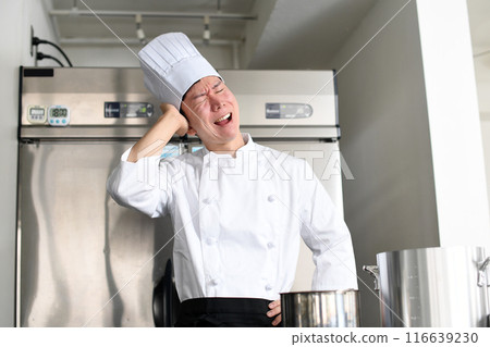 Worried young Asian female cook holding a pot Worried young Asian female cook holding a pot 116639230