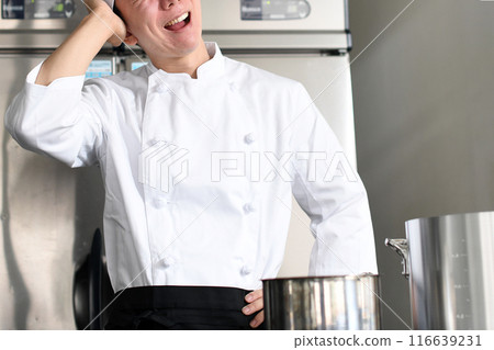 Worried young Asian female cook holding a pot Worried young Asian female cook holding a pot 116639231
