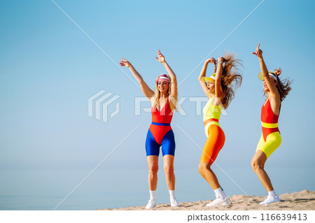 Three young woman in bright swimsuits dancing. Sport, summer, fitness, urban culture concept. 116639413
