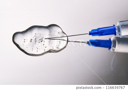 A drop of medicine flowing from a syringe with a needle. A drop of medicine flowing from a syringe with a needle. 116639767