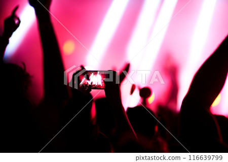 Hand with a phone records live music festival. People taking photographs with smart phone during concert. Hand with a phone records live music festival. People taking photographs with smart phone during concert. 116639799