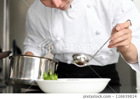 Young asian male chef serving food on plates in the kitchen Young asian male chef serving food on plates in the kitchen 116639814
