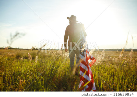 4th of July. American Flag. Traveler with the flag of America. The man in a hat, a backpack, a shirt and jeans. 116639954