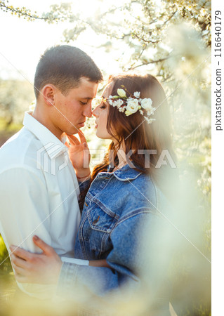 Beautiful loving couple in blooming gardens. Wedding concept. Great sunset light. Lovely newlyweds. 116640179