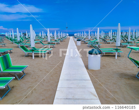 Summer. The sunbeds and parasols on the empty beach 116640185