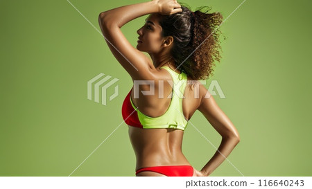 Middle Eastern female from behind in a sporty red neoprene bikini vibrant lime studio background 116640243