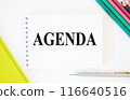 Top view of pen and notebook written with Agenda on white background with folder and pencils. Agenda Meeting Appointment Activity Information Concept, agenda word. bright picture 116640516